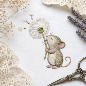 May include: An embroidery design on white fabric featuring a small gray mouse with pink ears and tail holding a white dandelion puff. The mouse has its eyes closed. The design includes delicate stitching details and a pair of metal scissors.