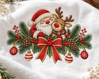 May include: A white fabric towel featuring an embroidered design of Santa Claus and a reindeer side by side. The scene includes green pine branches, brown pinecones, red berries, a large red bow, and four hanging Christmas ornaments.