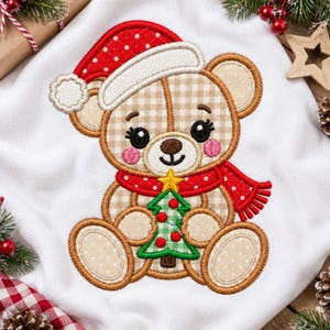 May include: An embroidered design on white fabric featuring a tan and beige gingham teddy bear wearing a red polka dot Santa hat and scarf. The bear holds a small green gingham Christmas tree with red ornaments and a yellow star on top.