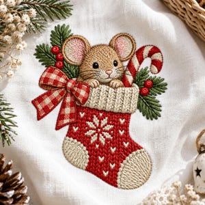 Op de afbeelding: Een geborduurd ontwerp op witte stof met een bruine muis die uit een rood-witte kerstsok in breistijl kijkt. De sok is versierd met een rood-wit geblokte strik, groene dennentakken, rode bessen en een zuurstok.