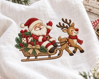 May include: A white fabric towel featuring an embroidered design of Santa Claus in a red suit sitting in a brown sleigh filled with green and white gift boxes, pulled by a brown reindeer wearing a red scarf, accented with green pine branches.