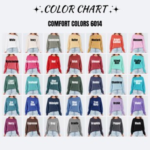 May include: A color chart for Comfort Colors 6014 long-sleeve shirts, displaying 42 swatches of shirts in various colors including white, ivory, sandstone, butter, mustard, salmon, blossom, watermelon, crunchberry, red, brick, crimson, island reef, and mint.