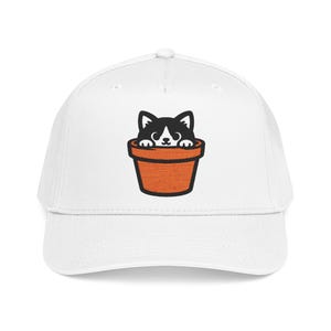 May include: A white baseball cap featuring a centered graphic of a black and white cat peeking out from inside a terracotta-colored flower pot. The design uses bold black outlines and a simple, clean aesthetic on the front of the cap.