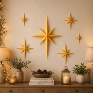 May include: A set of six three-dimensional yellow star wall decorations in varying sizes. Each star features a multi-pointed geometric design with sharp, angular rays extending from a central point, creating a symmetrical and faceted appearance.