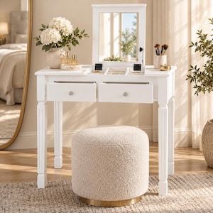 May include: A white vanity table with a flip-top mirror, two drawers, and a central storage compartment. The vanity features four fluted legs and is paired with a round, cream-colored, textured fabric ottoman with a gold-toned metal base.