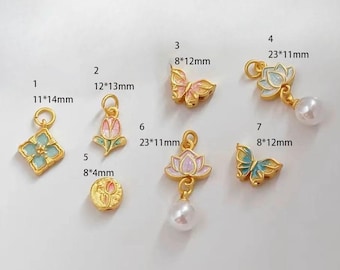 May include: Ten gold-tone charms with enamel floral and butterfly designs. The charms are various sizes and feature a mix of pink, blue, and green enamel. Some charms have a pearl attached.