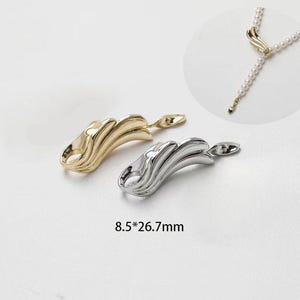 Puede incluir: Dos cierres en forma de ala de oro y plata para collares o pulseras. Los cierres miden 8,5 por 26,7 milímetros.