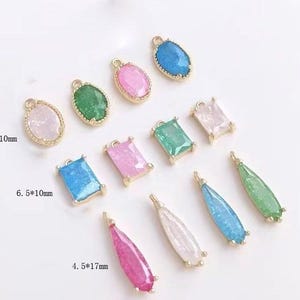 May include: Assortment of colorful glass and metal charms in various shapes, including oval, rectangle, and teardrop. The charms are approximately 6.5 x 10 mm and 4.5 x 17 mm in size.