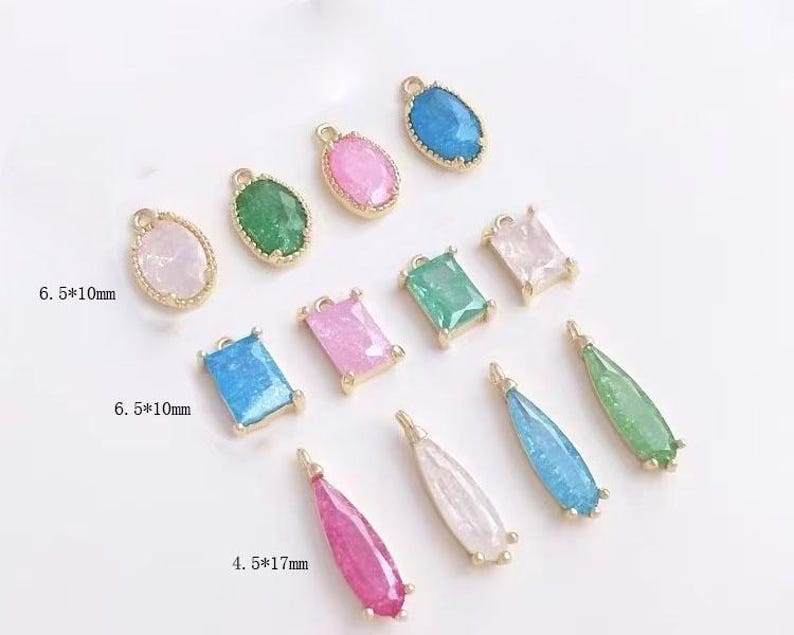 May include: Assortment of colorful glass and metal charms in various shapes, including oval, rectangle, and teardrop. The charms are approximately 6.5 x 10 mm and 4.5 x 17 mm in size.