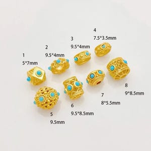 May include: Ten gold-colored beads with turquoise stones. The beads are of various sizes and shapes, including round, square, and cylindrical. The beads are labeled with numbers 1 through 8 and measurements in inches.