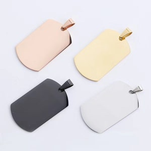 Può includere: Quattro targhette per cani vuote in diversi colori: oro rosa, oro, nero e argento. Le targhette sono in metallo e hanno una forma rettangolare arrotondata.