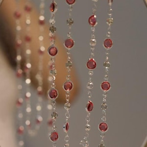 Peut inclure: Trois brins de collier en chaîne argentée avec des perles rondes roses.