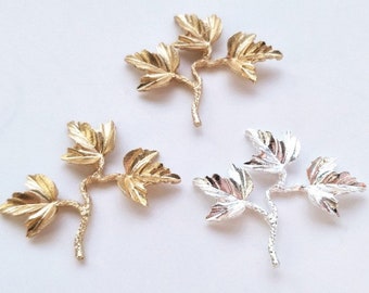May include: Three gold leaf sprigs with a textured finish. Each sprig has three leaves and a stem.