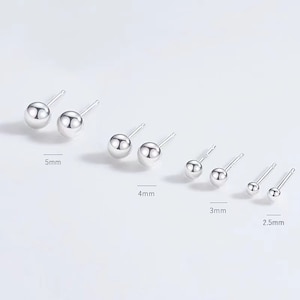 May include: Set of six silver stud earrings with different sized round balls. The earrings measure 2.5 mm, 3 mm, 4 mm, and 5 mm in diameter.