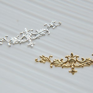 Peut inclure: Deux ornements métalliques ornés, l'un argenté et l'autre doré, avec un motif floral délicat. Ces pièces décoratives sont parfaites pour ajouter une touche d'élégance à l'artisanat, aux bijoux ou à la décoration intérieure.