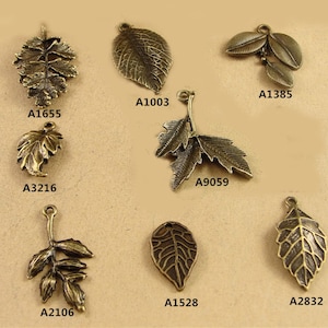 Peut inclure: Assortiment de huit breloques en forme de feuilles dor&eacute;es anciennes avec diff&eacute;rents motifs. Les breloques sont &eacute;tiquet&eacute;es avec des codes produits : A1655, A1003, A1385, A3216, A9059, A2106, A1528 et A2832.