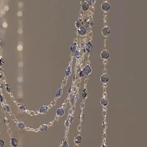 Könnte beinhalten: Eine silberne Kettenkette mit mehreren Strängen kleiner, runder, blauer Edelsteine.