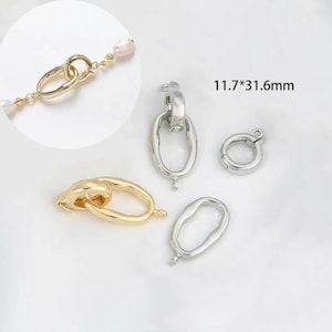 May include: Four silver and gold metal clasps for jewelry making. The clasps are oval shaped and have a spring-loaded closure. The clasps measure 11.7 by 31.6 mm.