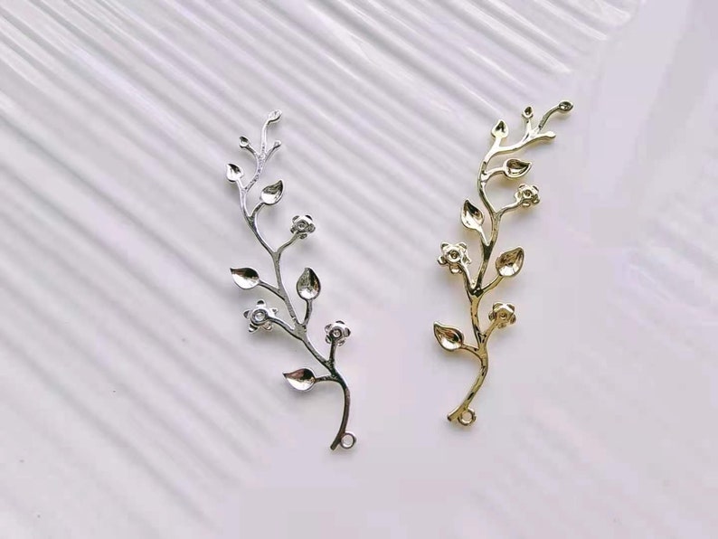 May include: Two metal floral branch embellishments, one gold and one silver, with small flower details. These are perfect for adding a touch of elegance to crafts and jewellery.