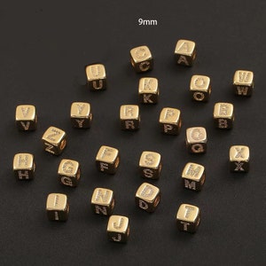 Puede incluir: Una colección de cuentas de letras del alfabeto doradas de 9 mm. Cada cuenta es un cubo con una letra en cada lado. Las letras son A, B, C, D, F, G, H, I, J, K, L, M, N, O, P, Q, R, S, T, U, V, W, X, Y y Z.