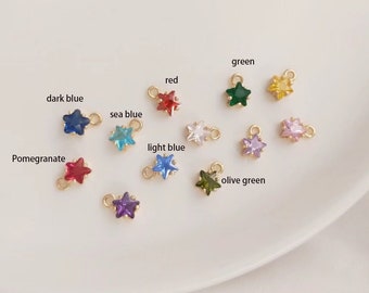 May include: Assortment of star-shaped charms with different colored crystals. The colors include red, green, dark blue, sea blue, light blue, olive green, pomegranate, and purple.