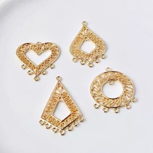 Puede incluir: Cuatro abalorios de pendientes de metal dorado con intrincados diseños de filigrana. Los abalorios tienen forma de corazón, diamante, círculo y lágrima.