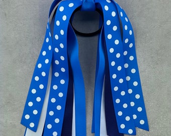 May include: Blue and white polka dot hair ribbon with a navy blue ribbon and a white ribbon. The ribbon is tied in a bow and is ready to be worn in hair.