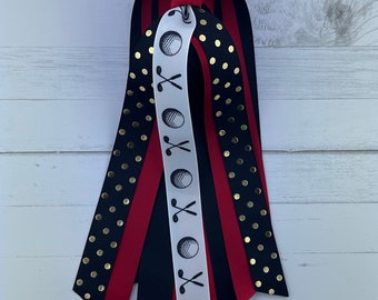 May include: A set of six ribbon hair ties featuring a golf ball and golf club design. The ribbons are black, red, white and gold with black polka dots.