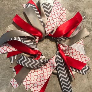 May include: A red, gray, and white ribbon hair tie with a variety of patterns, including chevron, geometric, and solid.