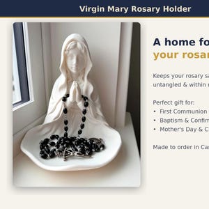May include: A white ceramic Virgin Mary figurine with hands clasped in prayer, featuring a wide, shallow base designed to hold a black beaded rosary with a silver-toned crucifix. The text reads: Virgin Mary Rosary Holder, A home for your rosary.
