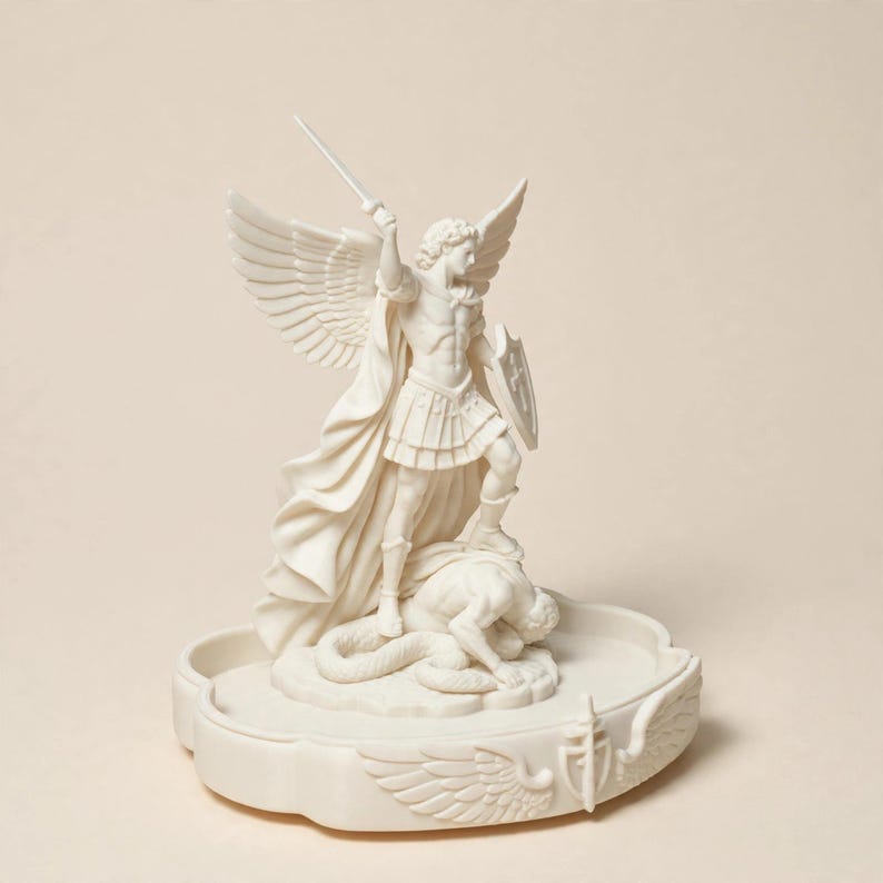 May include: A cream-colored statue of an archangel with large wings, wearing armor and holding a sword raised high in one hand and a shield in the other, standing over a fallen figure on a circular base decorated with carved wings and a sword.