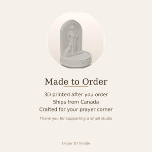 May include: A light gray 3D printed figurine featuring a standing figure in robes with a dog at their side, set against an arched backdrop with decorative relief carvings, all resting on a circular base with an ornate floral border design.