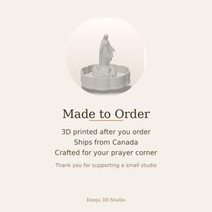 May include: A light gray 3D printed figurine of the Virgin Mary standing on a cloud base, set within a scalloped circular tray. The text reads: Made to Order, 3D printed after you order, Ships from Canada, Crafted for your prayer corner, Thank you for supporting a small studio, Danjo 3D Studio.
