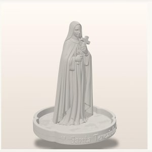 May include: A light gray monochromatic figurine of a nun wearing a habit and veil, holding a cross and a rose. The figure stands on a circular base with a scalloped edge, featuring the embossed text Sarita Terezinha along the front side.