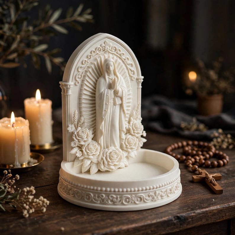 May include: An off-white resin sculpture featuring a central figure of a woman with hands clasped in prayer, framed by an arched structure with floral rose accents and a circular base tray, all rendered in a detailed, monochromatic relief style.