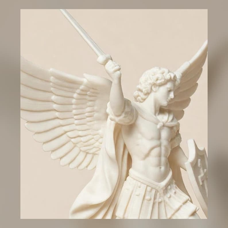 May include: A white, matte-finish sculpture of a winged figure in armor, holding a sword raised in the right hand and a shield in the left. The figure features detailed feathered wings, a muscular torso, and a draped cloak over the shoulder.