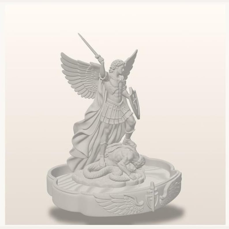 May include: A monochromatic white figurine depicting a winged figure in armor holding a sword aloft and a shield, standing over a prone figure on a circular base. The base features relief carvings of wings and a shield emblem on its outer edge.