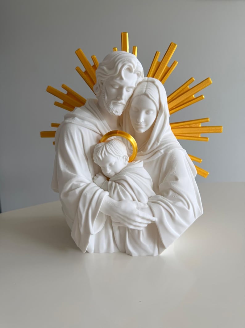 May include: A white sculpture of a family consisting of two adults and a child held in their arms. The figures have smooth, matte surfaces. Behind the adults is a bright yellow sunburst halo, and the child has a small yellow halo above their head.