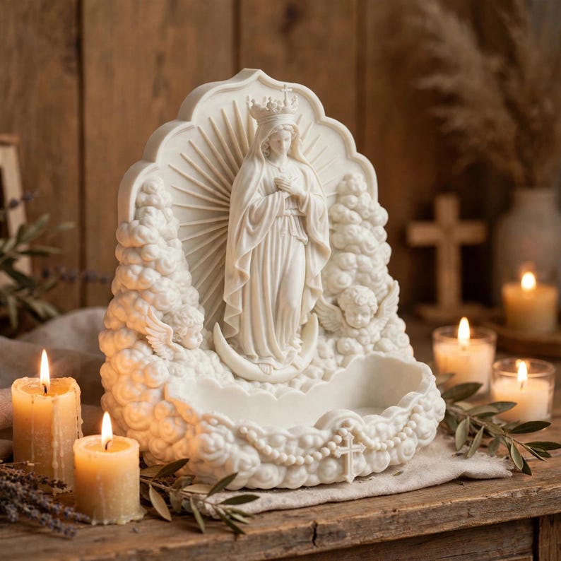 May include: A cream-colored resin wall font featuring a central figure of the Virgin Mary wearing a crown and standing on a crescent moon. The figure is surrounded by clouds, two cherubs, and a sunburst, with a small basin and a cross at the base.