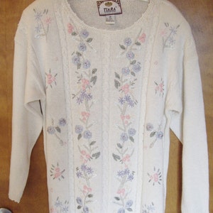 Cotton sweater with floral accents.