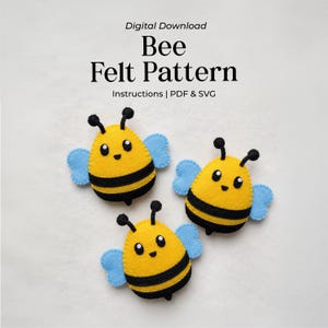 May include: Digital download Bee Felt Pattern Instructions | PDF & SVG. Three handcrafted felt bees with yellow bodies, black stripes, light blue wings, and black antennae, eyes, and mouths arranged on a plain light background.