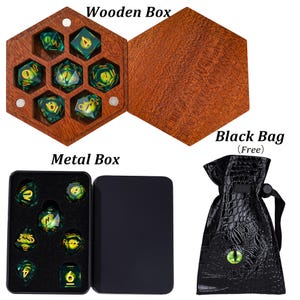 Puede incluir: Un juego de siete dados de ojo de drag&oacute;n verdes y amarillos con n&uacute;meros dorados, presentados en una caja de madera hexagonal o una caja de metal negro rectangular, junto a una bolsa negra texturizada con un emblema de ojo verde.