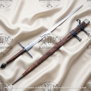 May include: A long, double-edged steel sword with a straight crossguard and a dark brown, textured wooden grip ending in a faceted pommel. Beside it lies a matching wooden scabbard featuring intricate carvings and dark leather suspension straps.