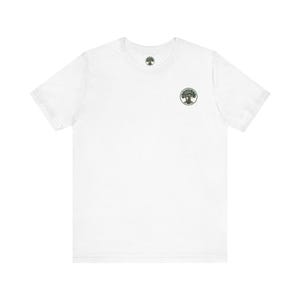 Puede incluir: Una camiseta blanca de manga corta con un pequeño logotipo circular en el pecho izquierdo. El logotipo representa un árbol verde estilizado con un tronco marrón dentro de un borde circular. La camiseta tiene un cuello redondo estándar.