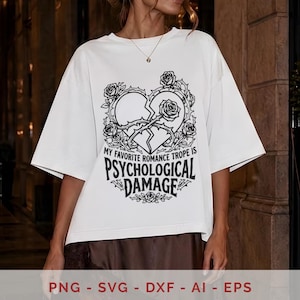 May include: A white short-sleeved t-shirt featuring a black graphic of a broken heart surrounded by roses and thorns. The text reads, "MY FAVORITE ROMANCE TROPE IS PSYCHOLOGICAL DAMAGE," printed in a bold, stylized font below the heart illustration.