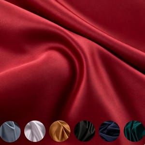 May include: A deep red satin fabric with a smooth, reflective surface and soft, flowing folds. Below the main fabric, six circular swatches display the same material in grey, white, gold, black, navy blue, and dark green colour variations.