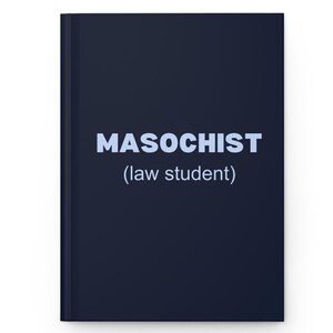May include: A dark navy blue hardcover notebook featuring the word MASOCHIST in large, light blue capital letters, with the text (law student) printed in a smaller, lighter blue font directly underneath the main word on the front cover.