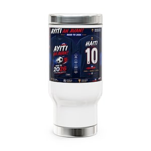 Puede incluir: Una taza de viaje blanca con un estampado gráfico de dos camisetas de fútbol azul marino. El frente muestra el texto AYITI AN AVAN! ROAD TO 2026 con un balón de fútbol, mientras que el reverso muestra HAITI 10. Incluye iconos y texto.