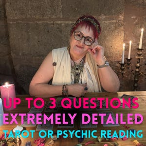 May include: A tarot or psychic reading service featuring a person with red hair and glasses, wearing a cream-coloured top and layered necklaces. The table displays tarot cards, candles, and scattered petals with the text UP TO 3 QUESTIONS EXTREMELY DETAILED.