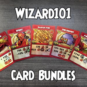 Op de afbeelding: Vijf Wizard101-ruilkaarten in een waaier, met rode randen en illustraties van Fire Dragon, Efreet, Rain of Fire, Sun Serpent en Fire From Above. De tekst WIZARD101 en CARD BUNDLES staat in het wit met een zwarte omlijning afgebeeld.